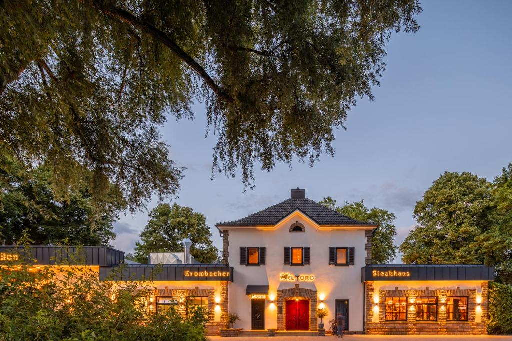 an exterior view of a white house at El Toro am Seilersee Suiten und Restaurant in Iserlohn