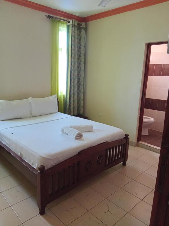 een slaapkamer met een groot bed met een spiegel bij Mtwapa Luxurious Residence with Pool B1M in Mombasa