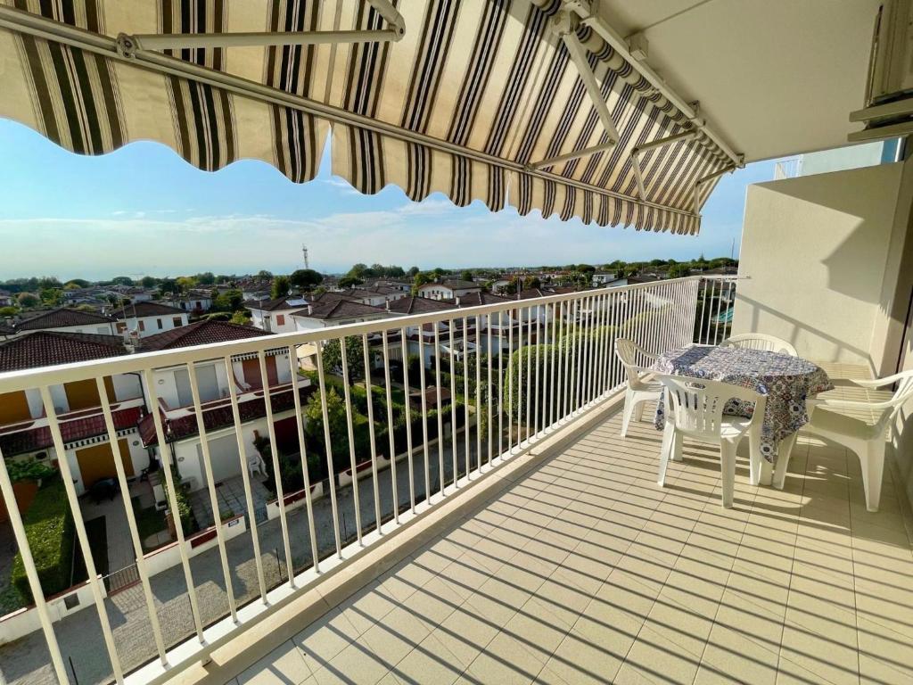 a balcony with a table and chairs on it at Comfy flat with terrace 250mt from the sea in Porto Santa Margherita di Caorle