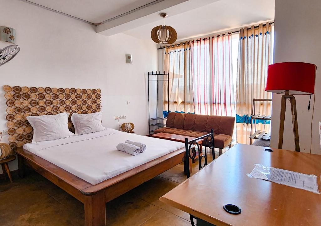 une chambre avec un lit, un canapé et une table dans l'établissement La Casa Di Luna - Hotel with Pool and Restaurant in Antananarivo, à Antananarivo