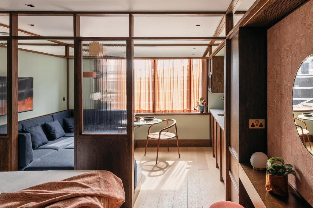 una camera da letto e un soggiorno con un divano blu di Locke at Postbyen a Copenaghen