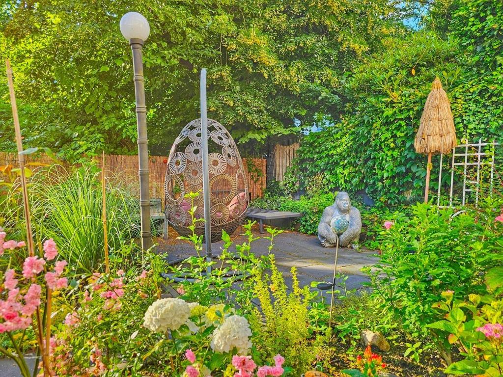 a garden with two statues sitting in a garden at 2 Zimmer Apartment am Zoo mit Garten in Wuppertal