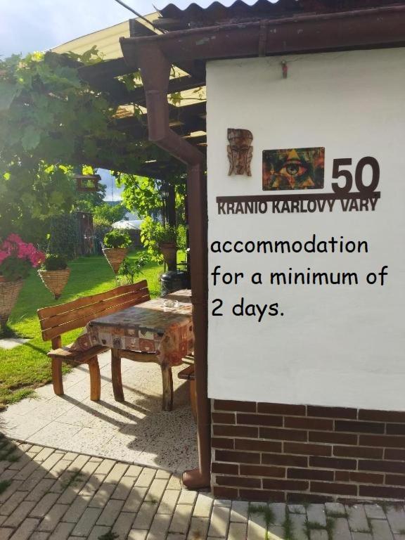 a sign with a bench next to a building at Kranio in Karlovy Vary