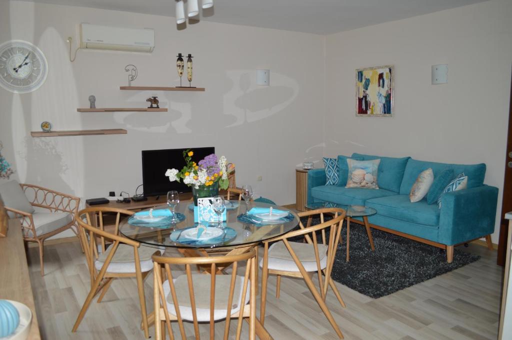 a living room with a table and a blue couch at Cozy apartment for overnight stays Hristo Smirnenski in Plovdiv