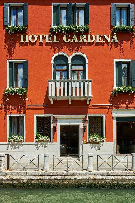 a red hotel with a hotel gardenena sign on a building at Hotel Gardena in Venice