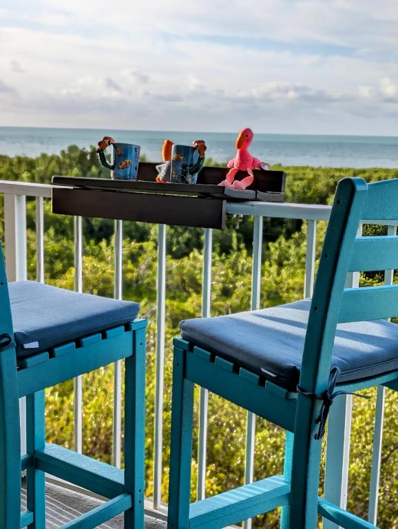 a table with two chairs and a doll sitting on a table at Ocean Oasis at Ocean Pointe in Tavernier