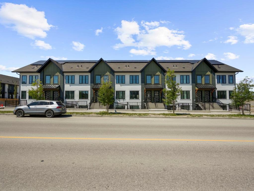 YYCにあるExquisite 1-Bdr Condo Aptの大きな建物の前に停車する車