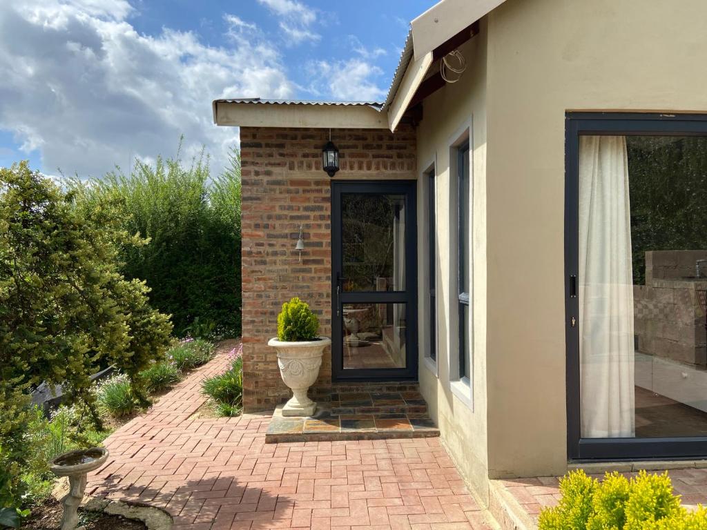 einer Haustür eines Hauses mit Topfpflanze in der Unterkunft Rosetta River Retreat in Mooirivier