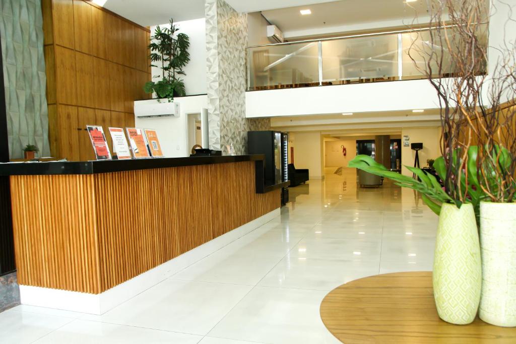 Un vestíbulo con un mostrador de recepción y una mesa. en Logic Hotel Volta Redonda, en Volta Redonda