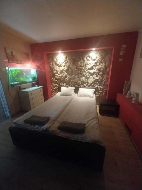 a bedroom with a large bed with a stone wall at Klimatyczny Zakątek pod Jasną Górą in Częstochowa