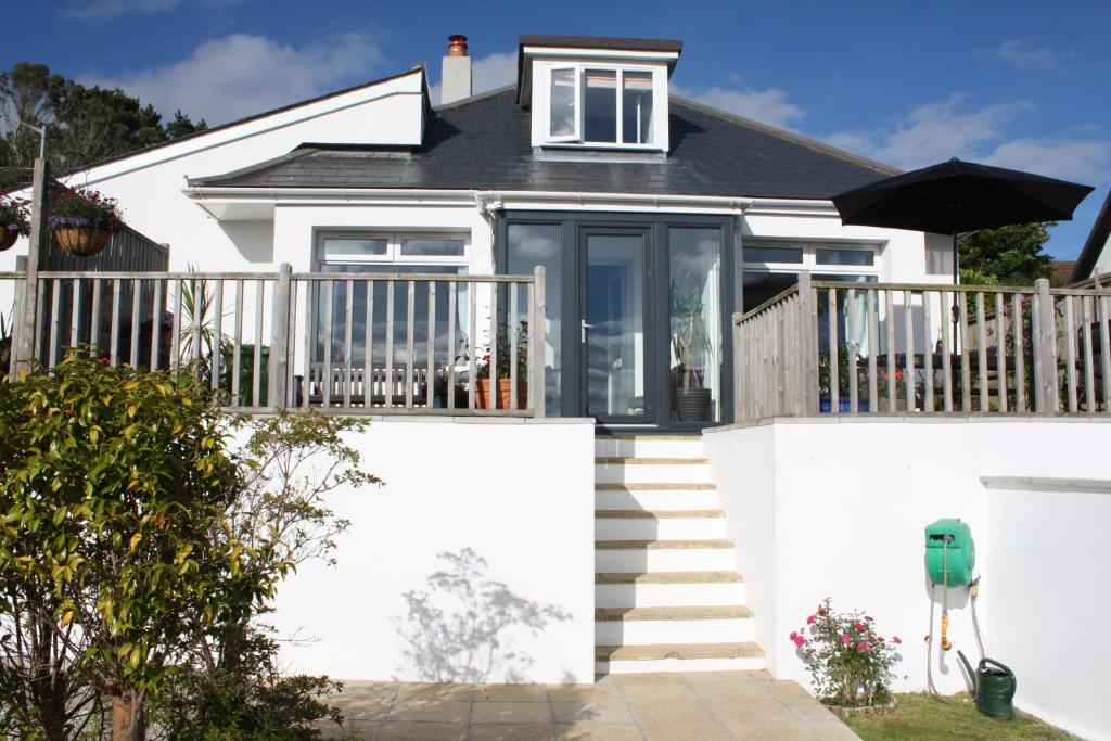 a white house with a deck and stairs at Linton Luxury Holiday Home in Mevagissey