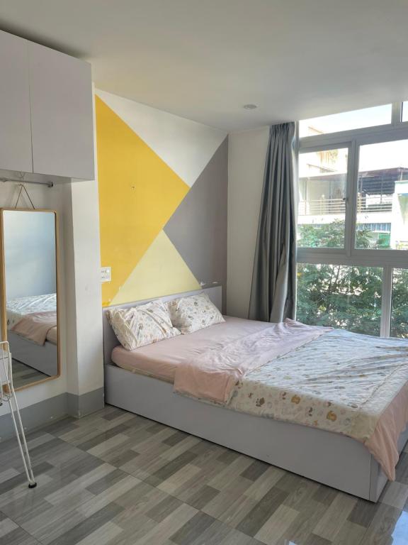 a bedroom with a large bed and a mirror at Ariel Homestay in Quy Nhon