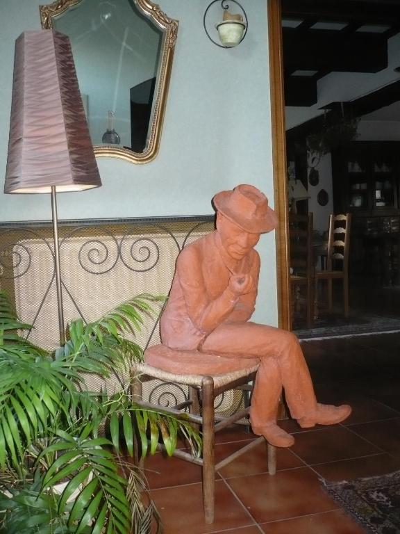 a statue of a man sitting on a bench at B&B El Tyu in Écaussinnes-dʼEnghien