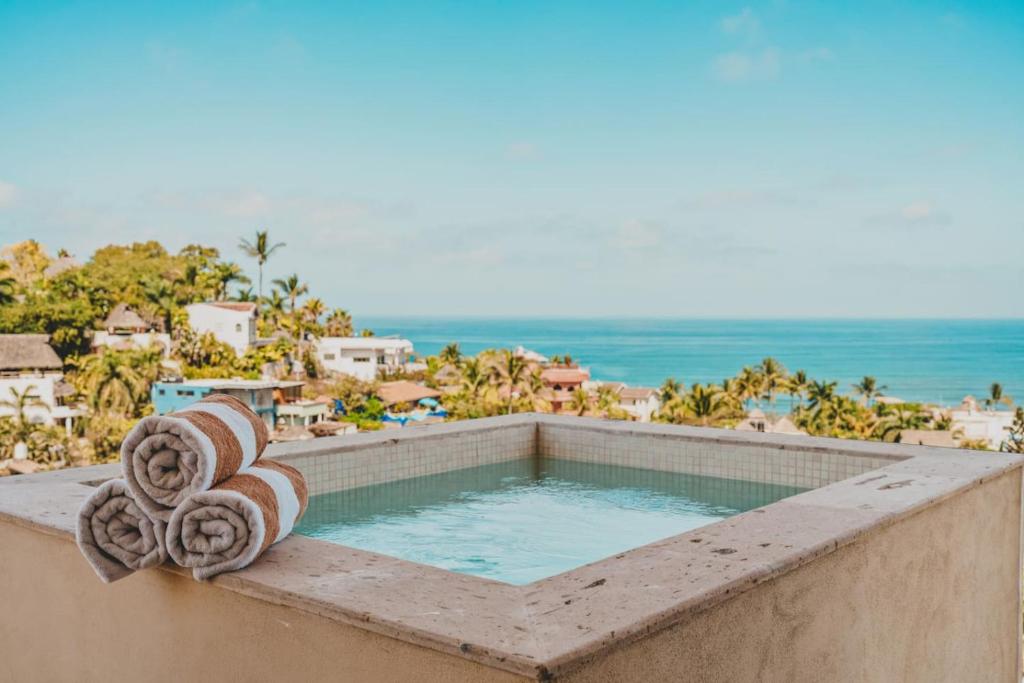 a swimming pool with the ocean in the background at Sayulita Serenity in Sayulita