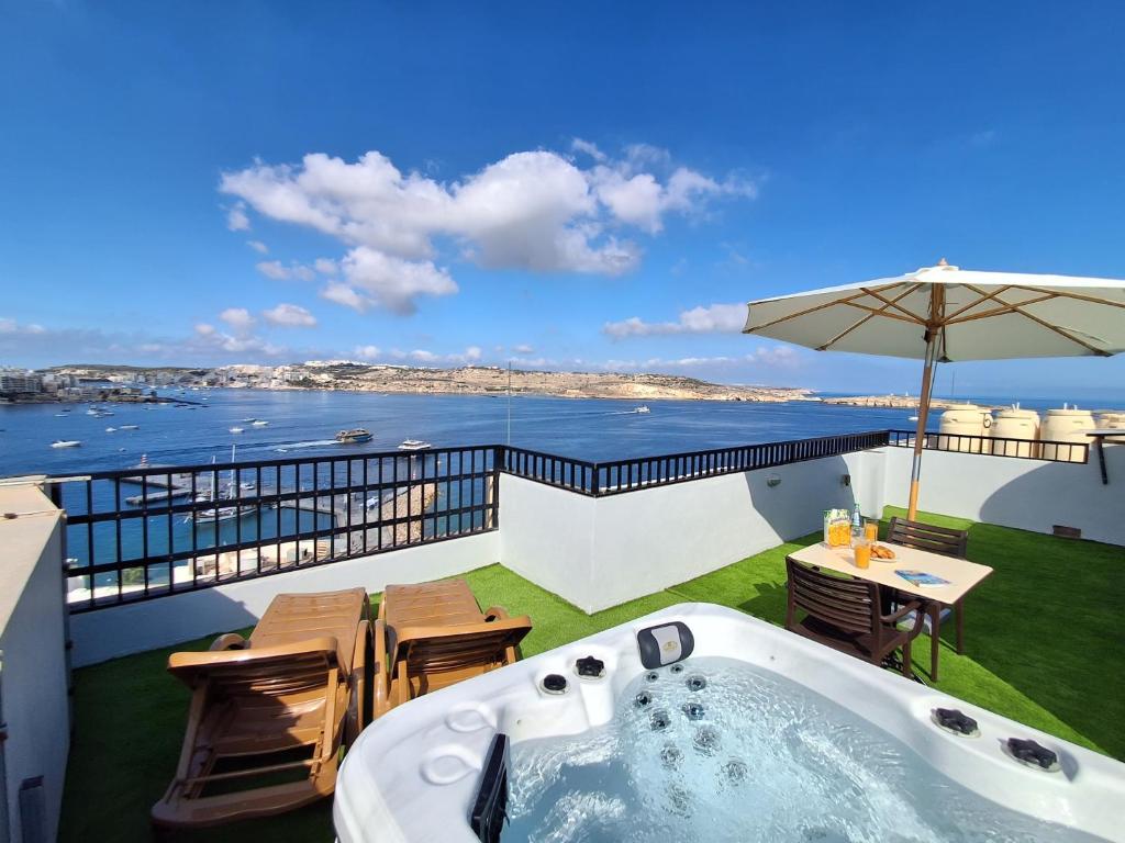 a hot tub on a balcony with a view of the ocean at Islet Promenade Studio with Hot Tub and Panoramic Sea Views by GetawaysMalta in St Paul's Bay