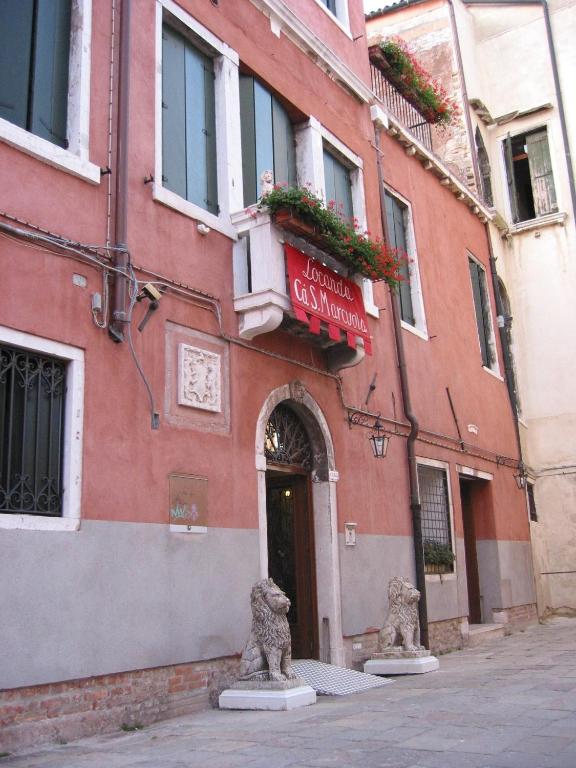 a red building with two statues in front of it at Guesthouse Ca&#39; San Marcuola 1 in Venice