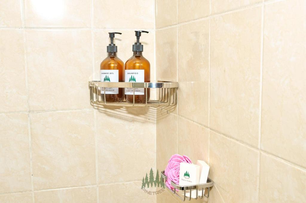 a bathroom with three bottles of alcohol on a wall at Pinetree Gardens Residence in Eldoret