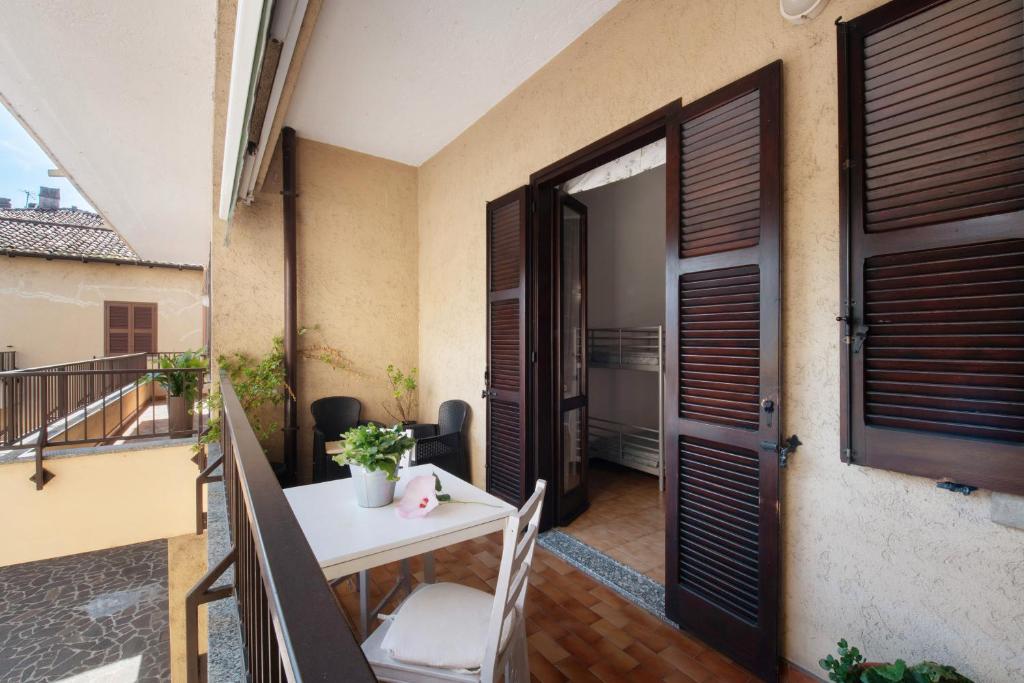 a small balcony with a table and a door at La Terrazza Di Basilio - Vista Lago in Olginate