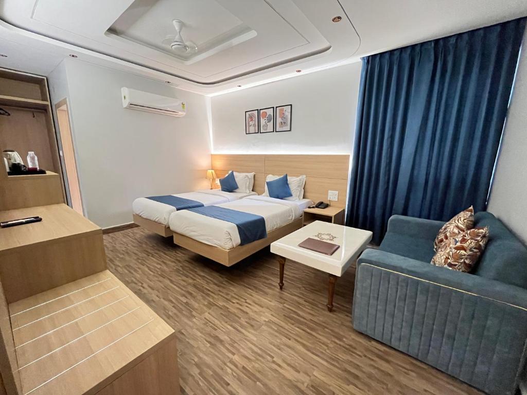 a hotel room with a bed and a couch at Hotel Paras in New Delhi