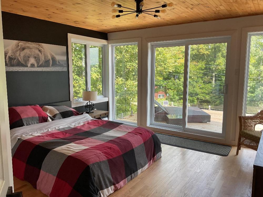 una camera da letto con un letto e una grande finestra di Chalet Bleu Ski In Ski Out With Spa a Mansonville