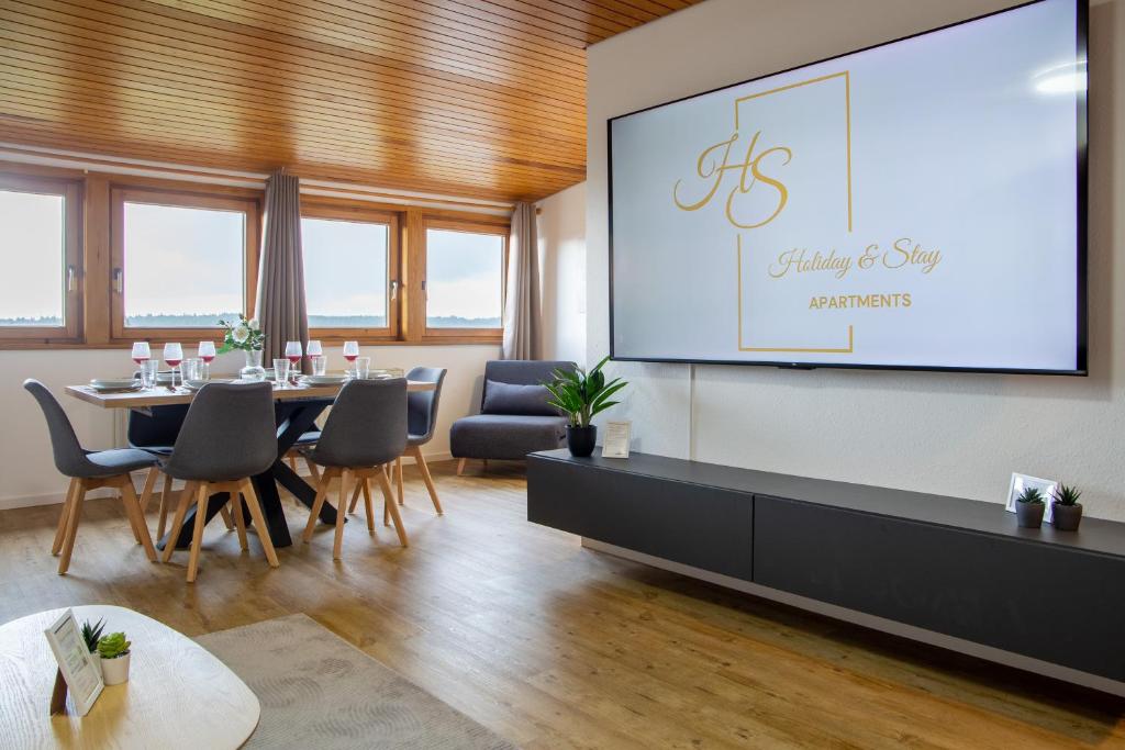 einen Tagungsraum mit einem Tisch und einer Leinwand in der Unterkunft Holiday&Stay Black Forest Pool 85 TV WLAN in Schönwald