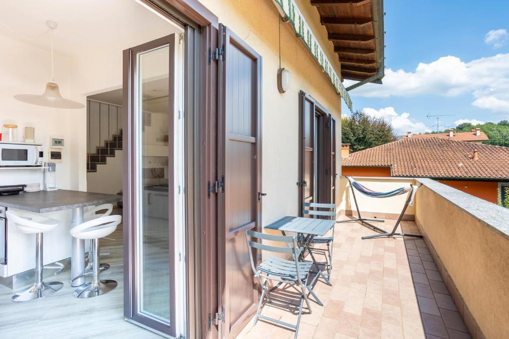 a balcony with chairs and a kitchen in a house at Rocca Lake House in Angera