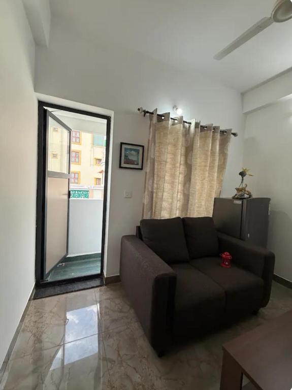a living room with a couch and a large window at The Cozy Cranny in Chennai