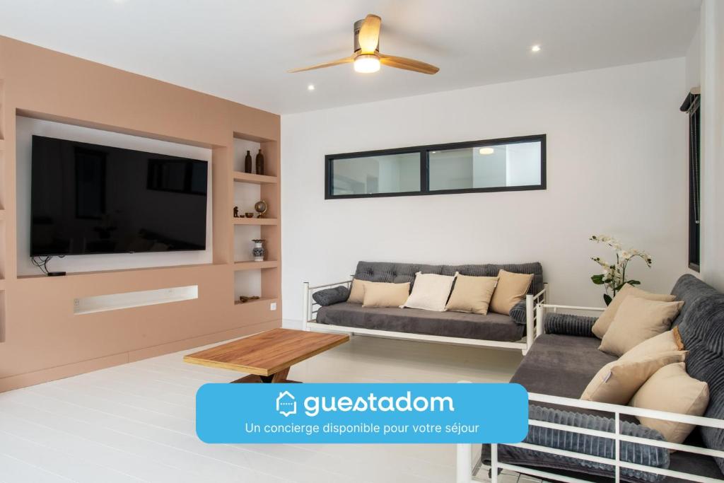Una sala de estar con un sofá y un televisor. en La Terrasse - Wifi - Parking - Clim, en Laval