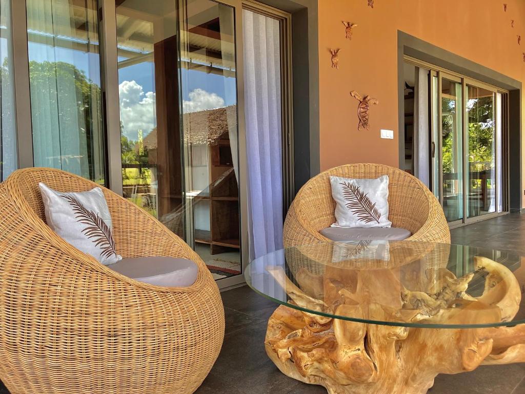 two chairs and a glass table in a room at Villas Kokoa Serena in Sainte Marie