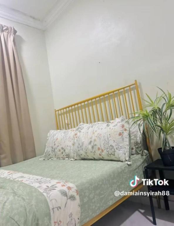 a bed with pillows on it in a room at CUTE Homestay in Tumpat