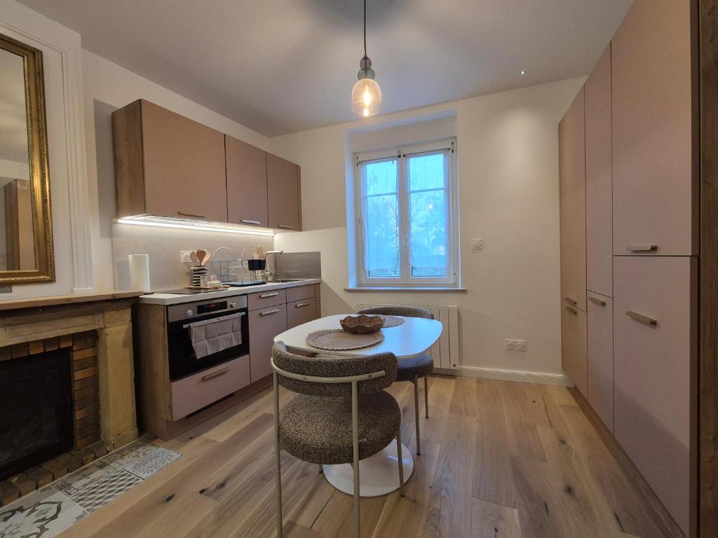 a kitchen with a small table and a stove at Studio proche de Metz in Sanry-lès-Vigy