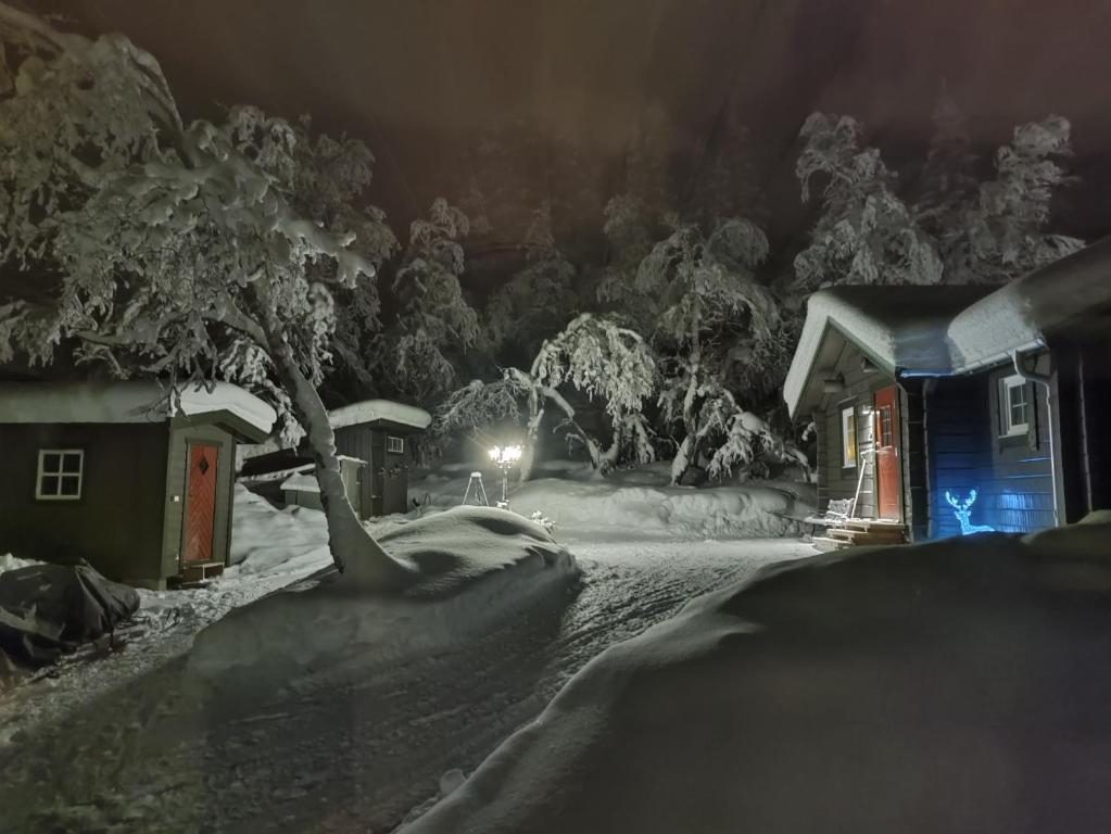 una casa cubierta de nieve por la noche con luz en Mysig liten stuga i Messlingen, en Messlingen