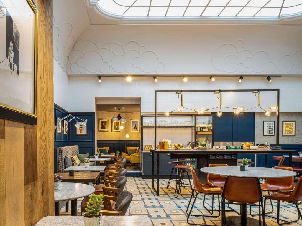 een restaurant met tafels en stoelen en een bar bij ibis Paris Grands Boulevards Opéra 9e in Parijs