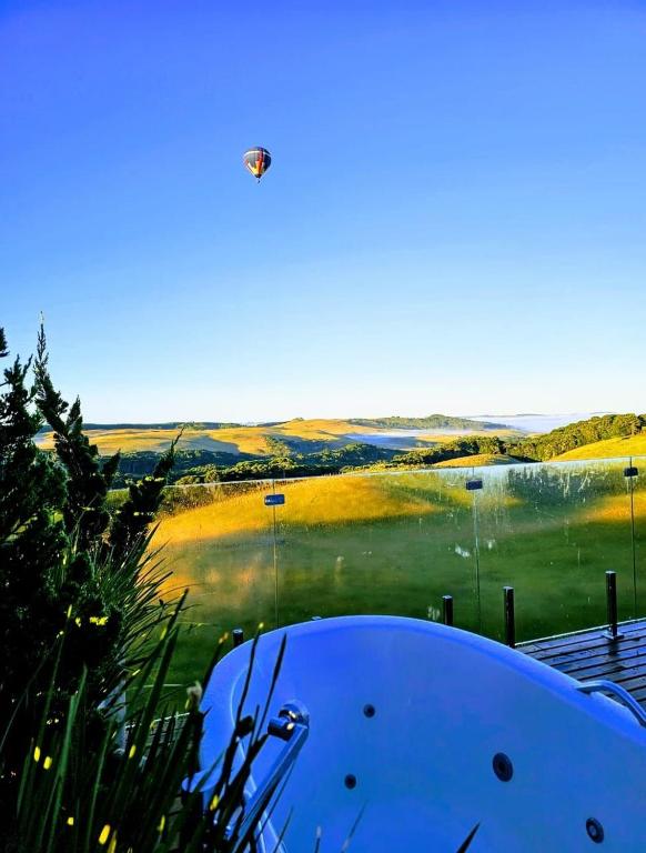 a person flying a kite over a body of water at Parador dos Canyons in Cambará