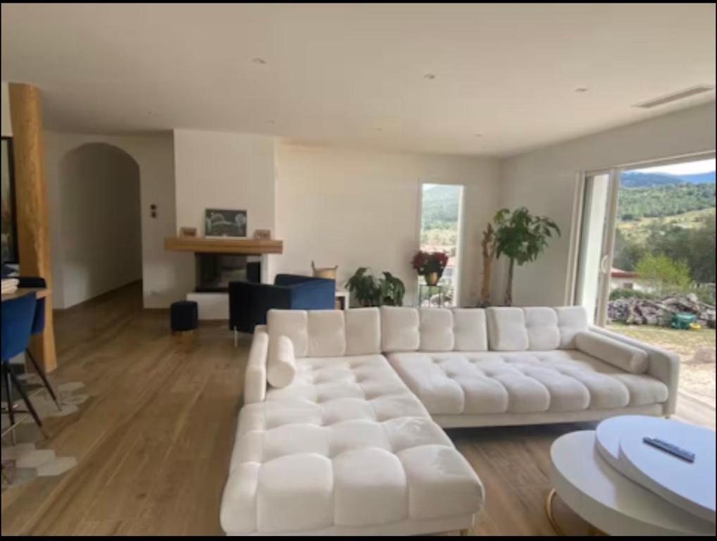 a white living room with a large white couch at Villa 4 chambres à Castirla in Castirla