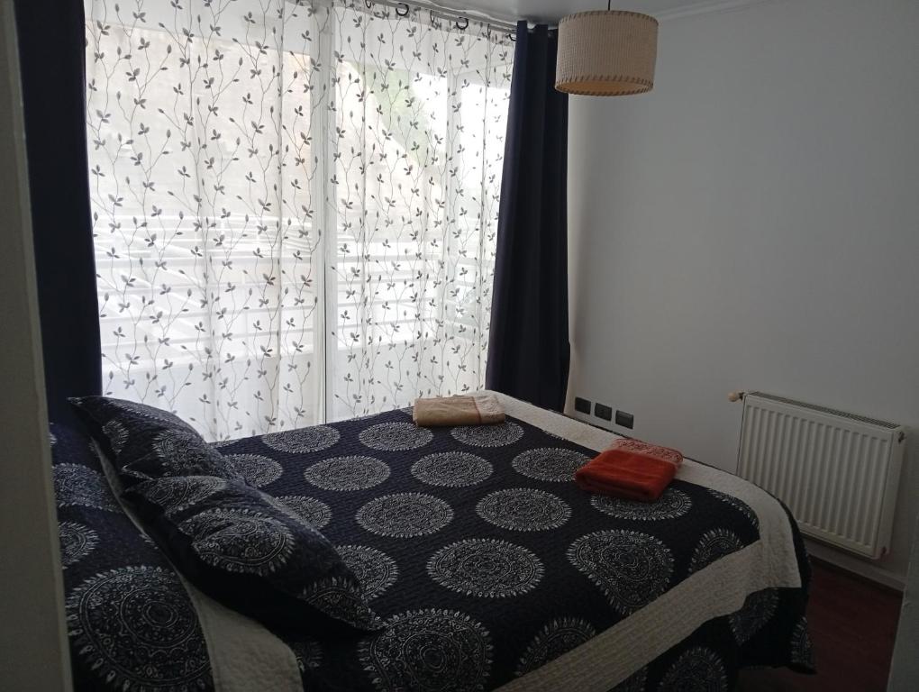 a bedroom with a bed and a window at Borde Costero in Valparaíso