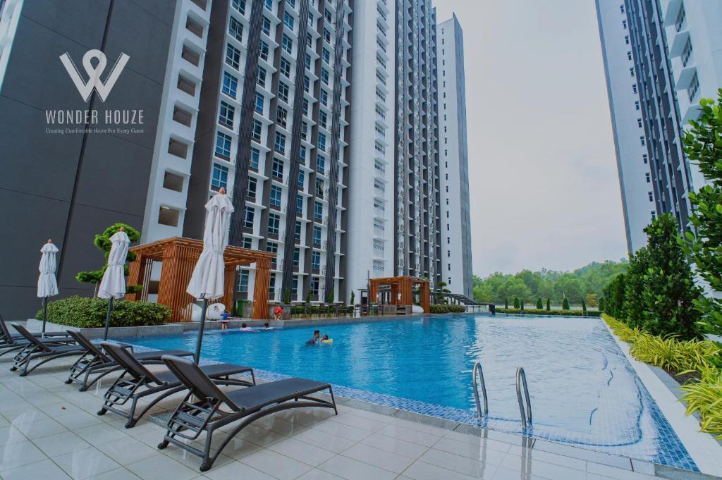 une piscine au milieu de deux grands bâtiments dans l'établissement 6pax Family-Friendly 3BR Stay in Kajang, à Kajang