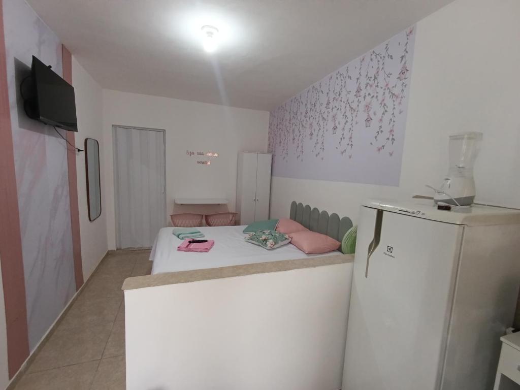 a small room with a bed and a refrigerator at Apartamento Privativo com Vaga in São Bernardo do Campo