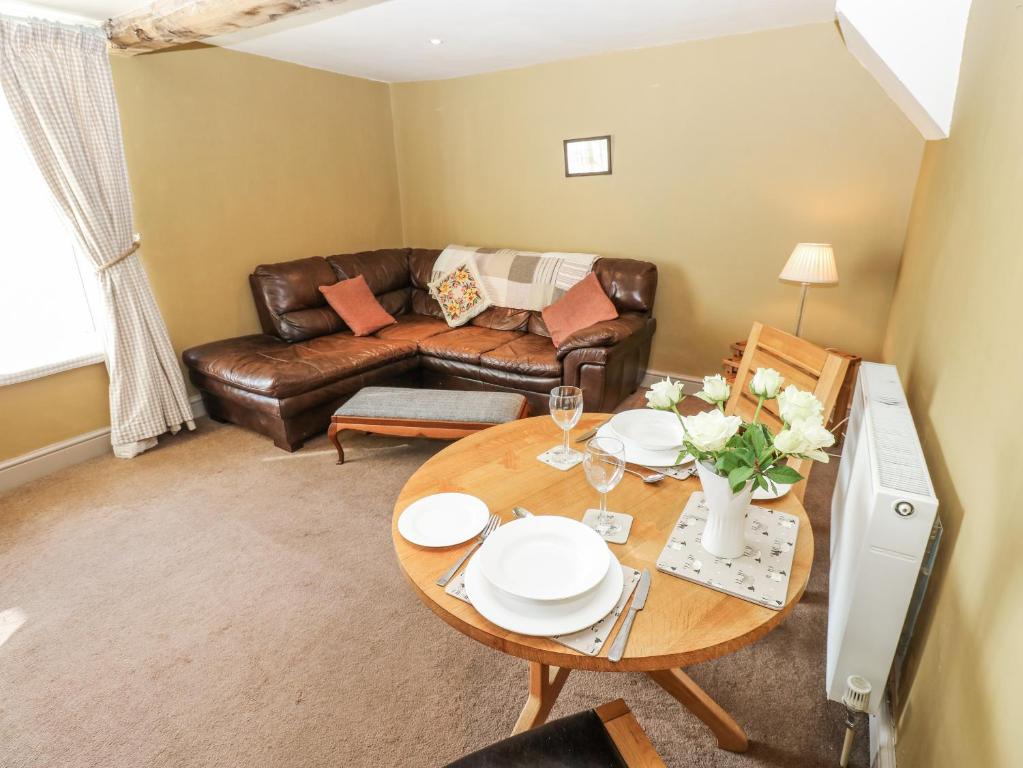 een woonkamer met een bank en een tafel bij Ewe Cottage in Masham