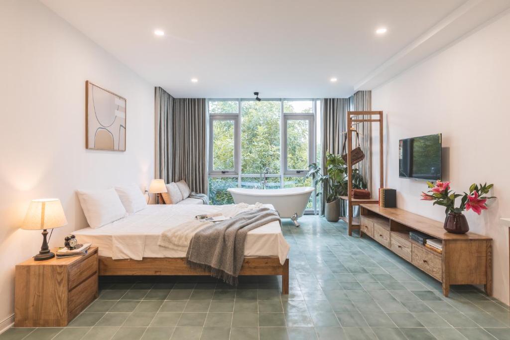 ハノイにあるThe Ivory Dragon Hanoi-Modern Stay with Private Balcony-Free Laundryのベッドルーム(大型ベッド1台、バスタブ付)