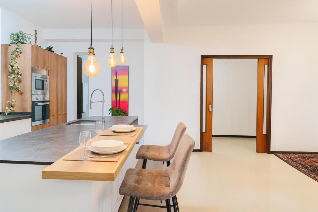 a kitchen with a wooden table and two chairs at Suite Enes Terrazza con vista e relax in centro città in Trieste