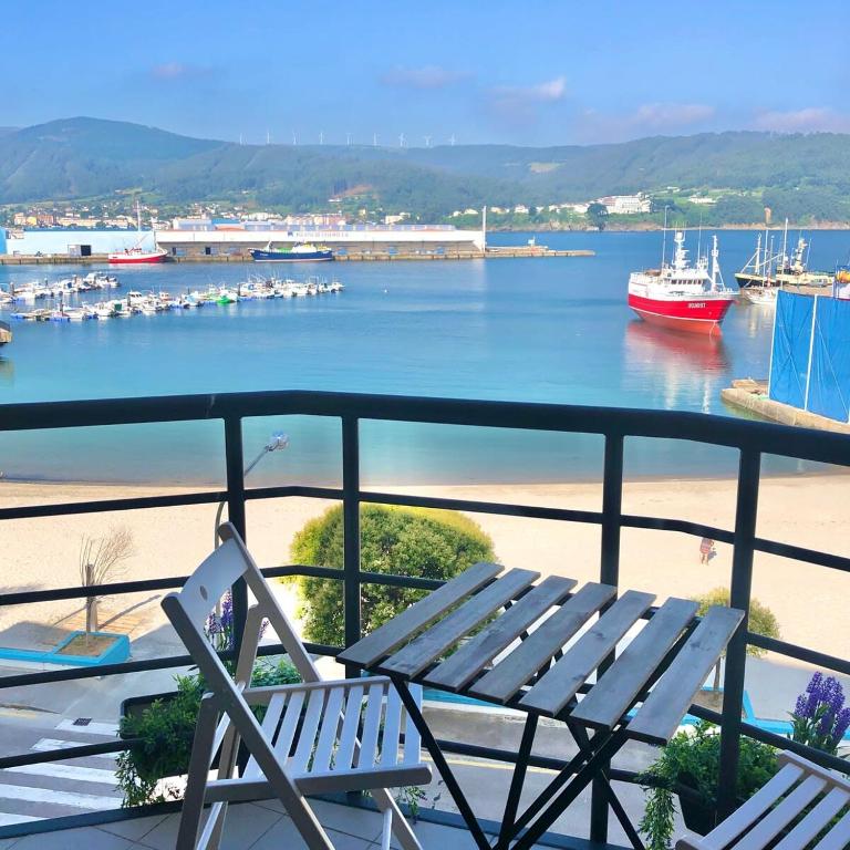 a balcony with two chairs and a view of a harbor at The Cliffs - Sunset Village Beach 3C in Viveiro