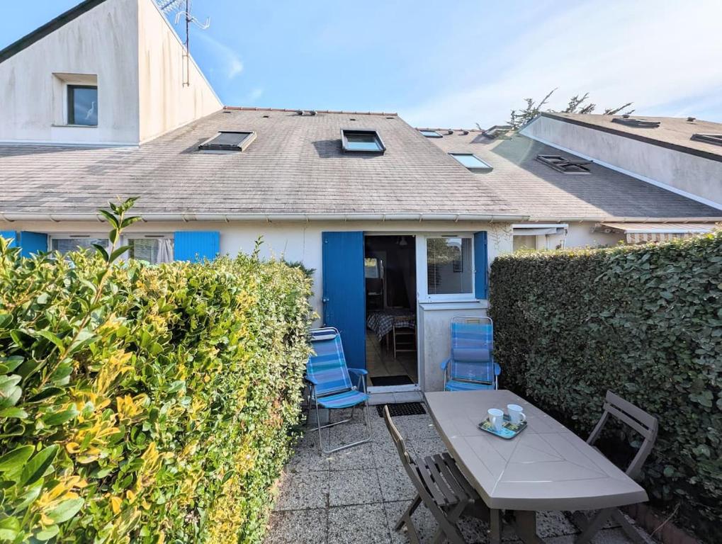 a table and chairs in front of a house at Séjour au calme -Maison 1 chambre pour 4 personnes - Plage à pied in Le Pouliguen