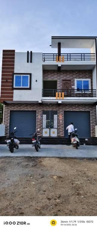 two motorcycles parked in front of a building at S M LODGe in Dharmapuri