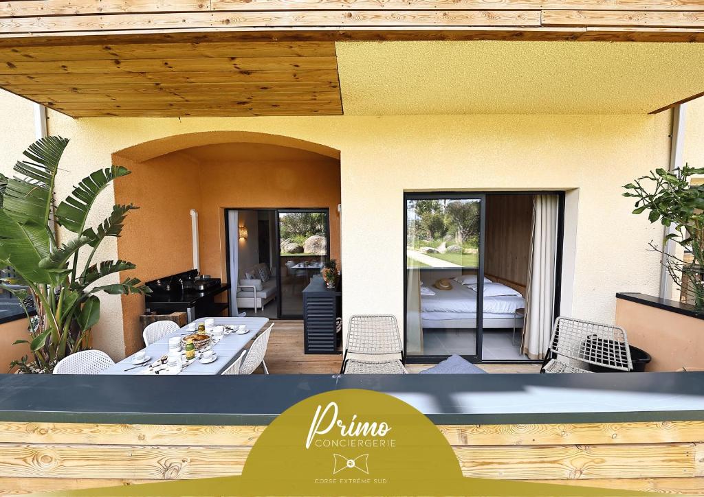 Una vista de un patio con una mesa y sillas. en U Bellu Paradisu - T3 vue mer, piscine, plage privé, en Pianottoli-Caldarello