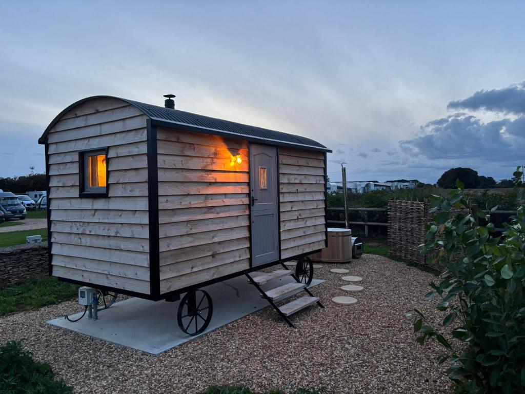a tiny house with a fire inside of it at Shepherd's Huts at Cotswold Hills Country Park in Chipping Norton