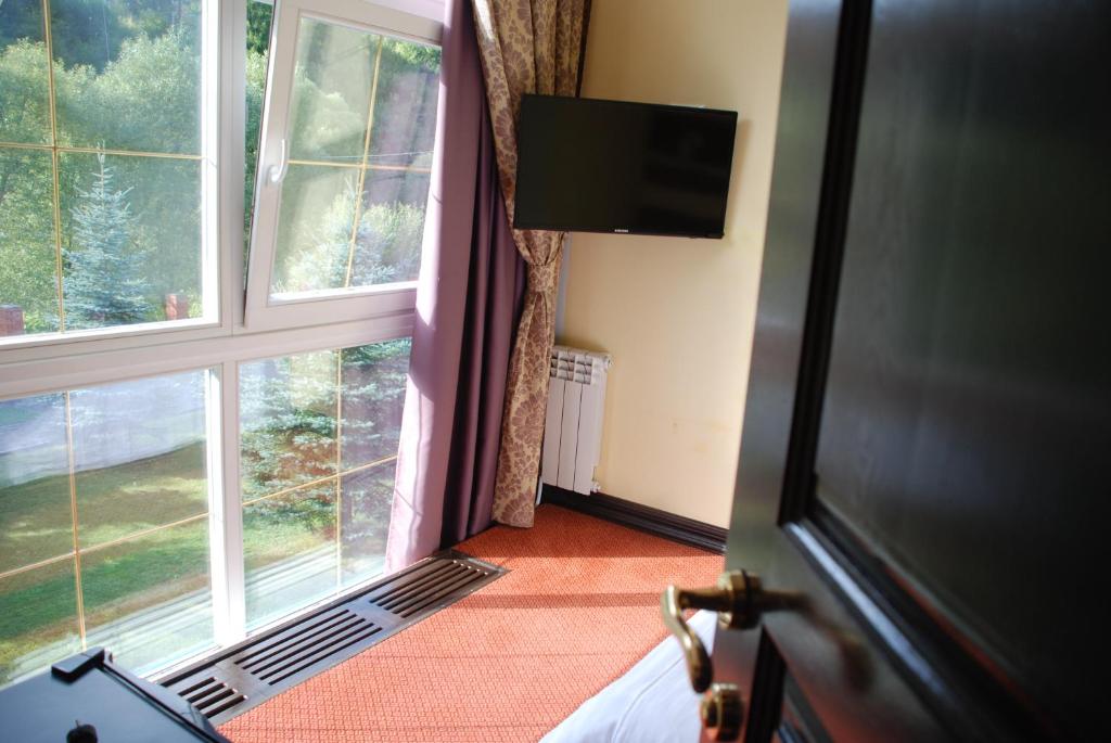 a room with a large window and a television at Chalet Zolota Pidkova in Slavske