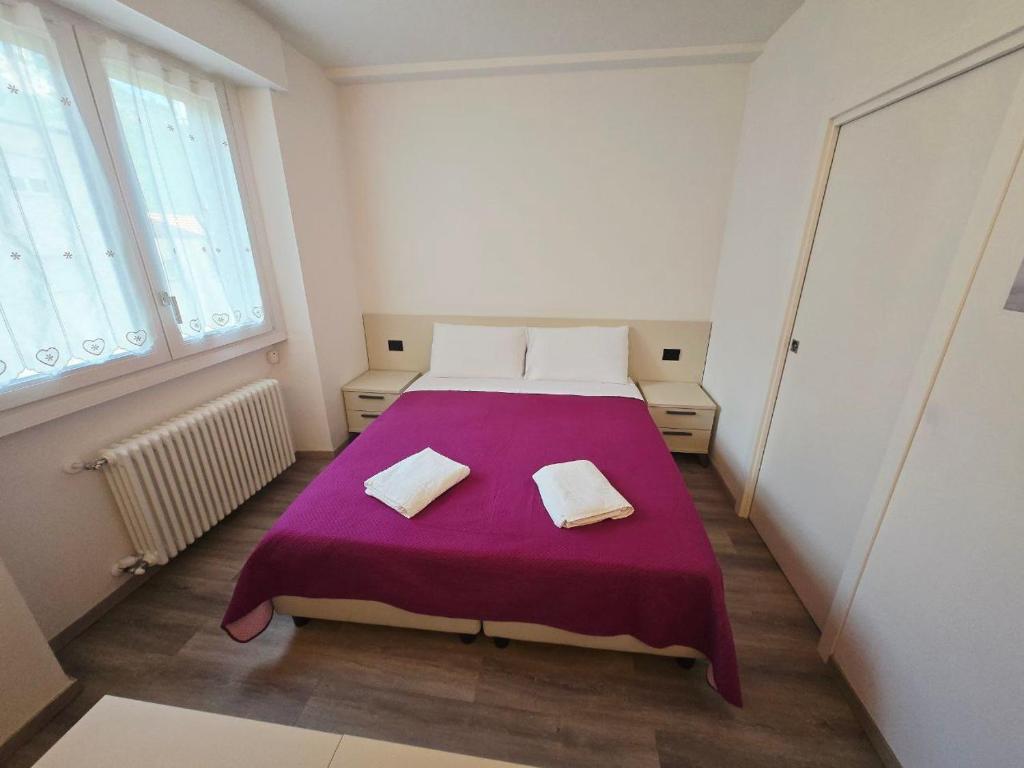 una camera con un letto e una coperta viola di Giagi B&B a Trento
