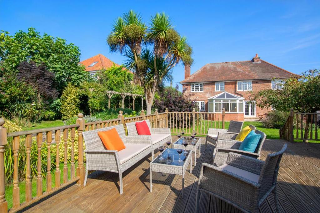 a deck with chairs and a table and a house at 5 Bed in Mundesley oc-2189 in Mundesley