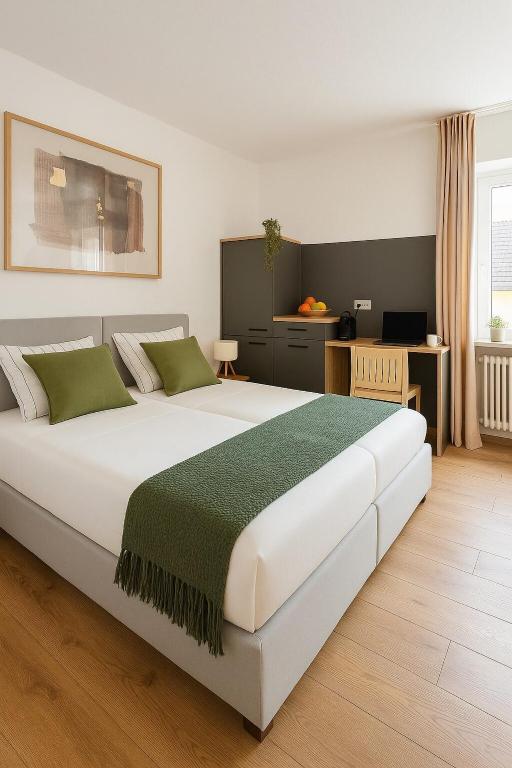 a bedroom with a large white bed with green pillows at Hotel weisses Lamm in Bruchsal